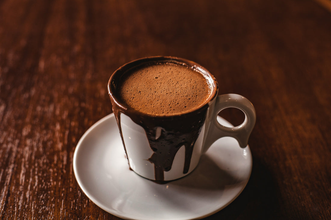 saffron hot chocolate in a ceramic mag on wooden brawn table