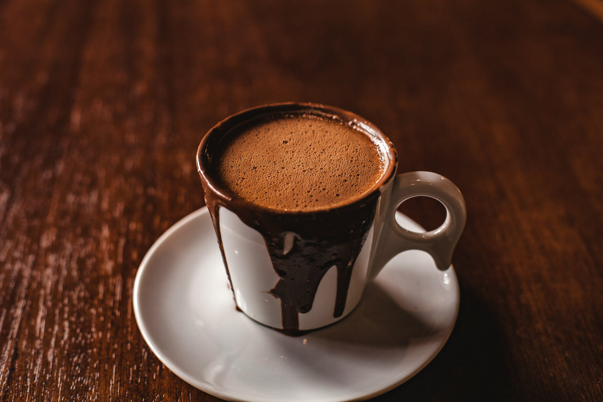 saffron hot chocolate in a ceramic mag on wooden brawn table