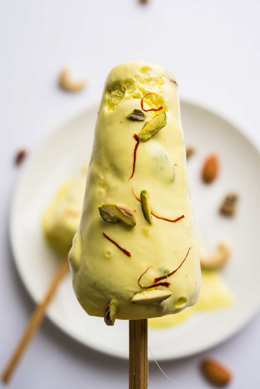 SaffronIice cream with a with plate and almonds in the backround. 