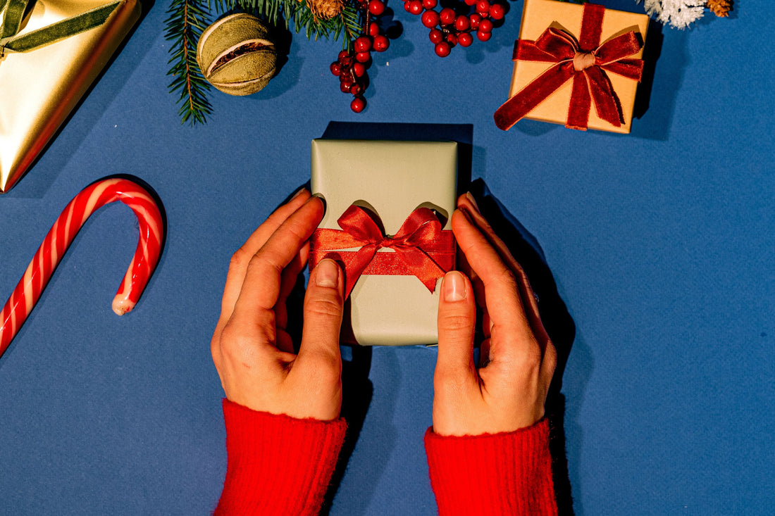 Gift with human hands next to it 