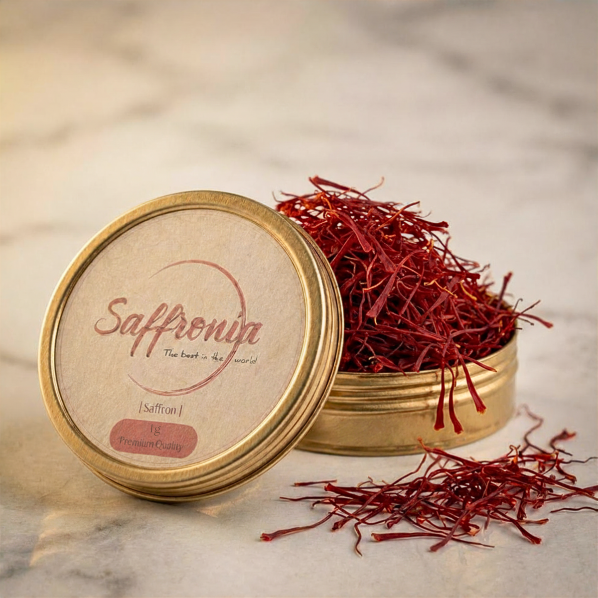 Saffron in a gold container with 'Saffronia' branding on a marble surface. 1gr Package of Saffronia Saffron